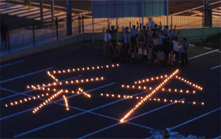 7月11日、多賀城キャンパスでキャンドルナイトを開催。当日は、学生、教職員をはじめ、本学附属幼稚園の先生や園児、近隣地域の方々も訪れた。このキャンドルナイトは震災後4ヵ月目で、追悼の意を込めて行なわれたもの。夕方6時30分からキャンドルが並べられ、7時過ぎには全てのキャンドルが灯り、多賀城キャンパス1号館前の駐車場に「絆」という字が浮かびあがった。この企画は、東北学院大学と立命館大学、関西学院大学でそれぞれキャンドルを灯し、その想や希望の光を集めて被災地へ届けようというもので、各大学での様子はSkype中継で繋いで、学生同士の交流というイベントも開催された